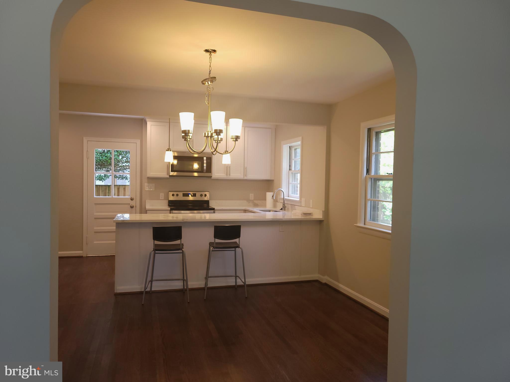 2250 North Quantico Street Arlington, VA 22205 - Photo 7 of 47 a dining room with wooden floor a chandelier a wooden table and chairs