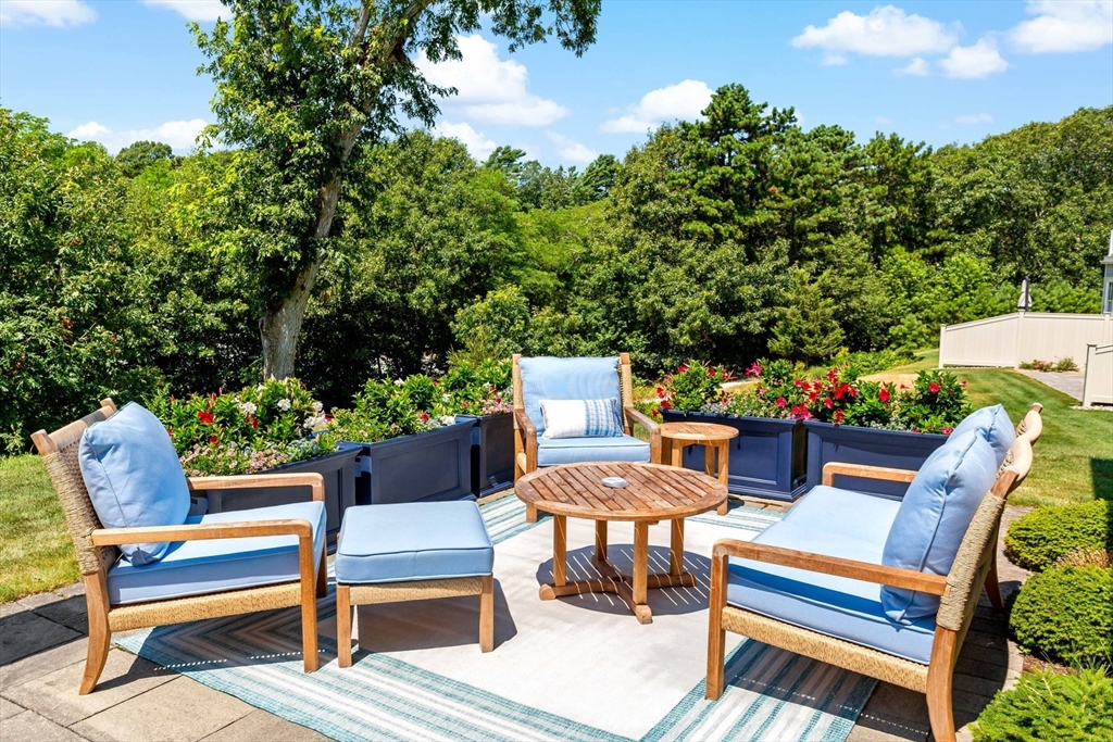 1090 Shore Road, Unit 4 Bourne, MA 02559 - Photo 34 of 42 a view of a chairs and table in the patio