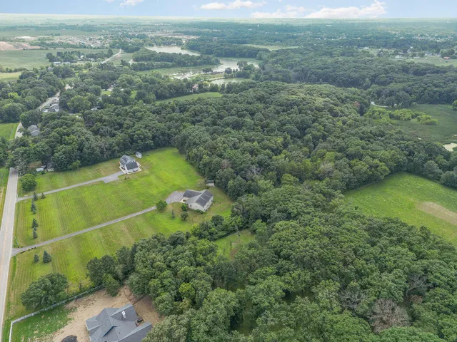 an aerial view of residential houses with outdoor space and trees