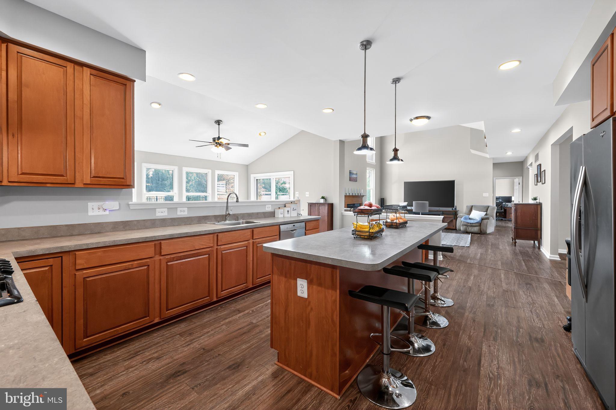562 Partridge Court Mickleton, NJ 08056 - Photo 11 of 33 a kitchen with stainless steel appliances kitchen island granite countertop a table chairs refrigerator and sink