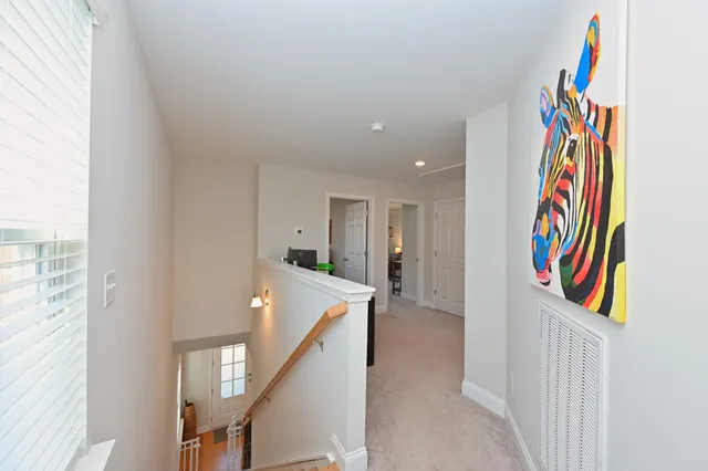 a view of a hallway with front door and wooden floor