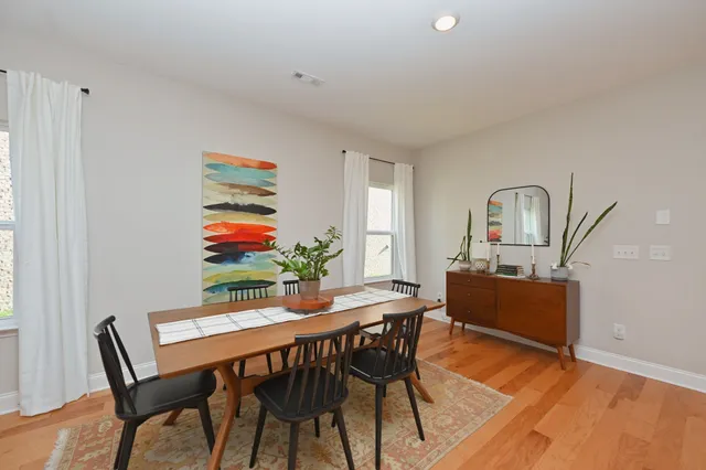 a view of a dining room with furniture a rug and wooden floor