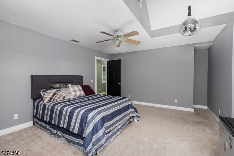 334 West Valley Brook Road Califon, NJ 07830 - Photo 24 of 44 a bedroom with a large bed and a chandelier