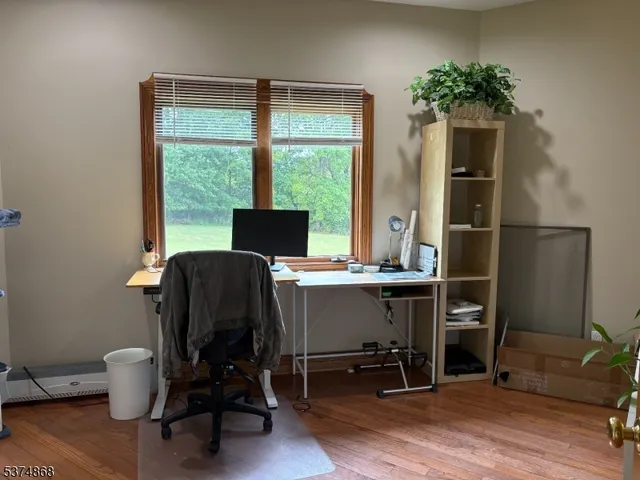 a view of a workspace with furniture and a window