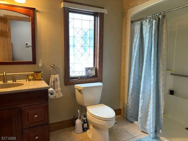 a bathroom with a granite countertop toilet sink and mirror