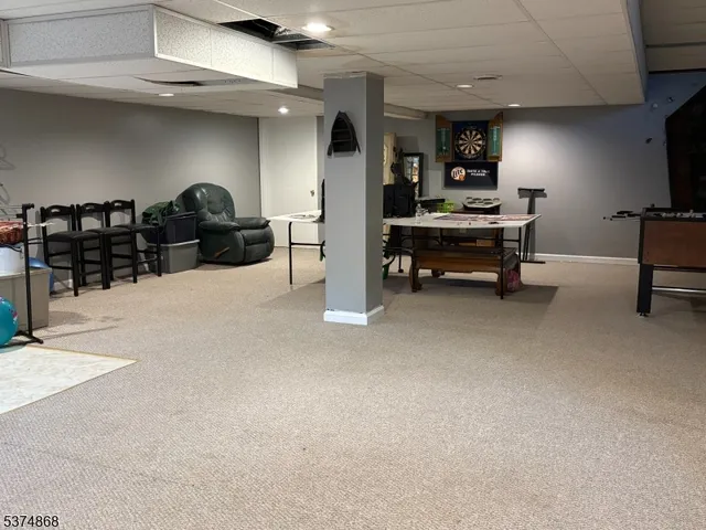 a living room with furniture a flat screen tv and gym equipment