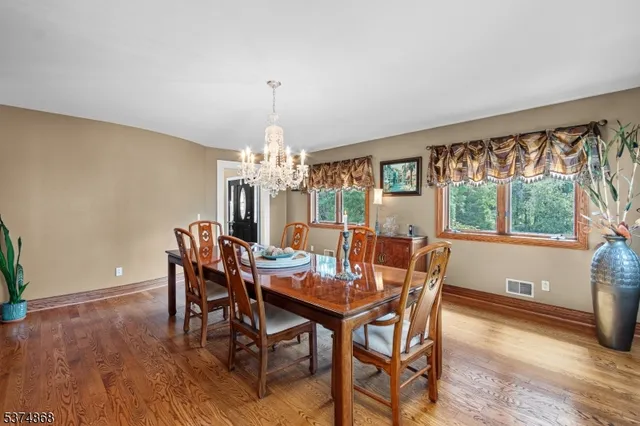 a view of a dining room with furniture a chandelier and wooden floor