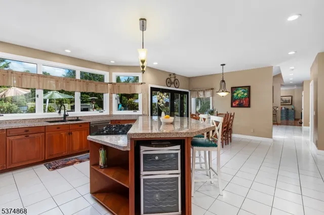 a kitchen with stainless steel appliances granite countertop a stove and a view of living room