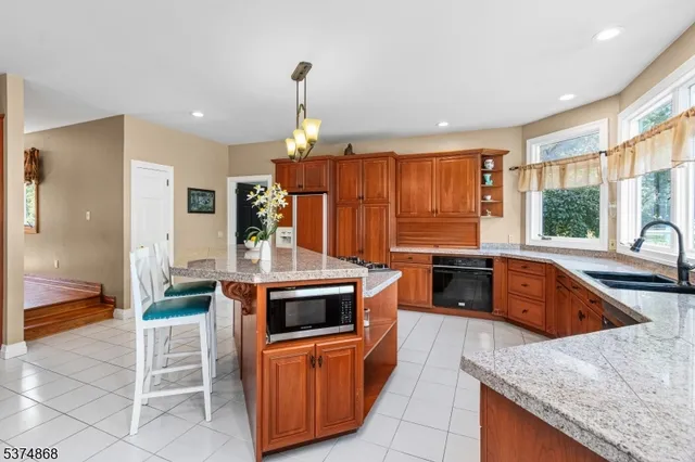 a kitchen with stainless steel appliances granite countertop a stove a sink and a refrigerator