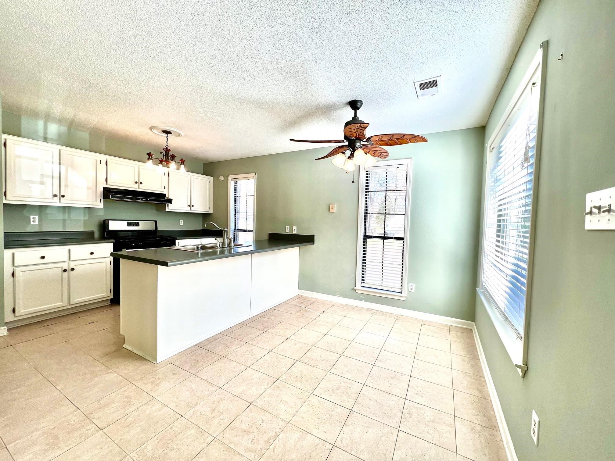 203 Glen Echo Road Collierville, TN 38017 - Photo 5 of 12 a kitchen with stainless steel appliances kitchen island granite countertop a stove a sink and a microwave