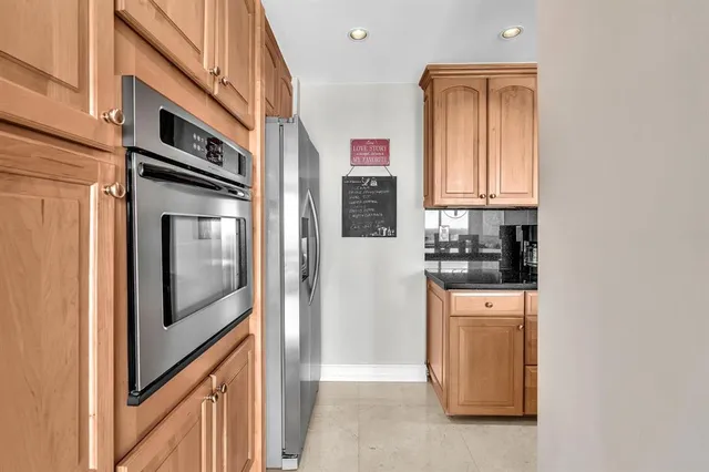 a kitchen with stainless steel appliances granite countertop a refrigerator and a sink