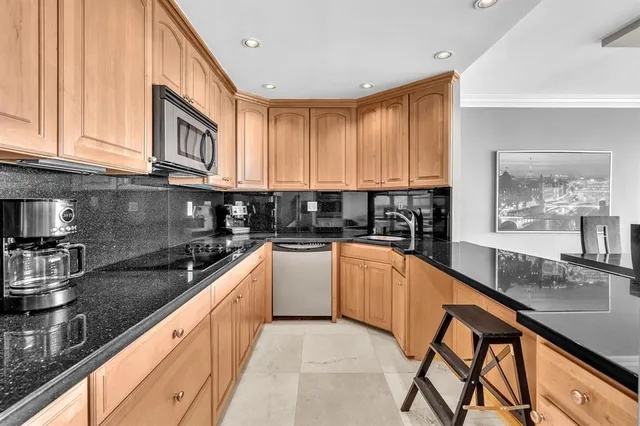a kitchen with stainless steel appliances granite countertop a sink stove and cabinets