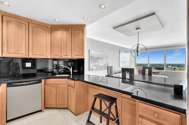 a kitchen with stainless steel appliances granite countertop a sink a stove and cabinets