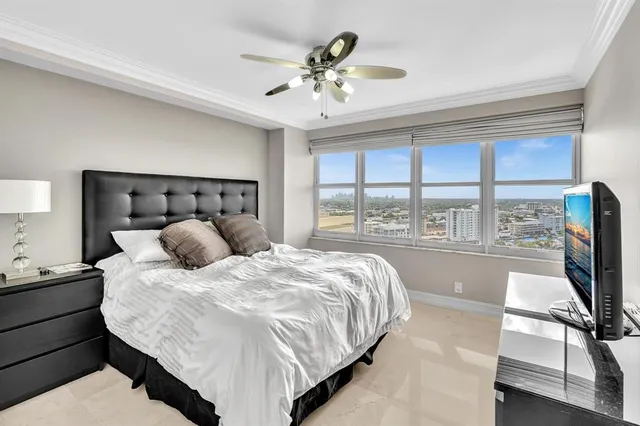 a bedroom with a bed and a large window