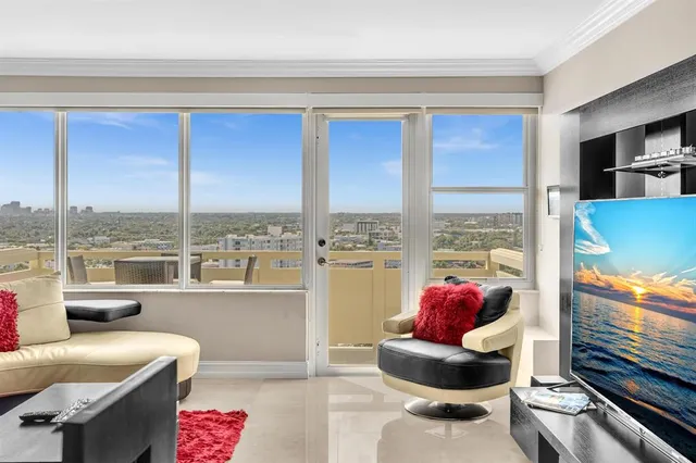 a living room with furniture and a floor to ceiling window