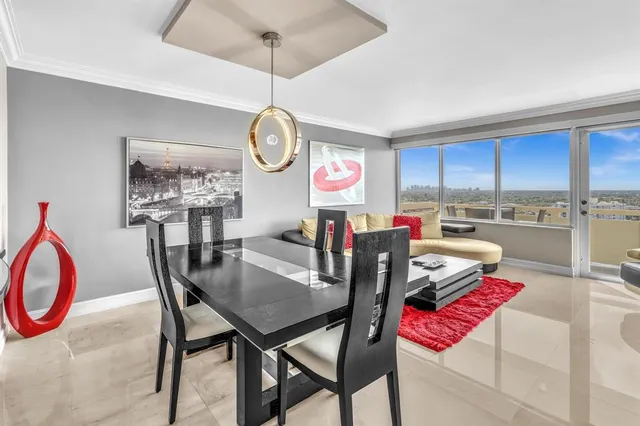 a dining room with furniture a kitchen a chandelier and wooden floor
