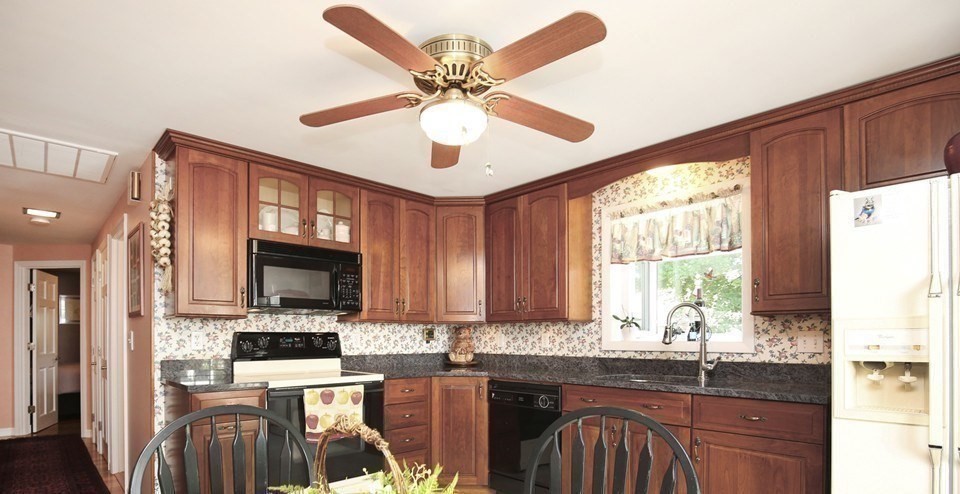 31 Fairchild Avenue Saugus, MA 01906 - Photo 5 of 24 a kitchen with stainless steel appliances granite countertop a stove top oven a sink a dining table and chairs