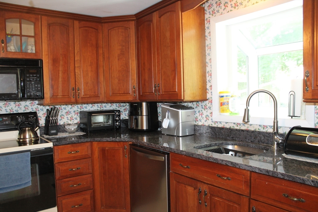31 Fairchild Avenue Saugus, MA 01906 - Photo 6 of 24 a kitchen with granite countertop a sink a stove and cabinets