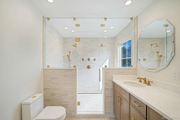 a bathroom with a sink a toilet and shower