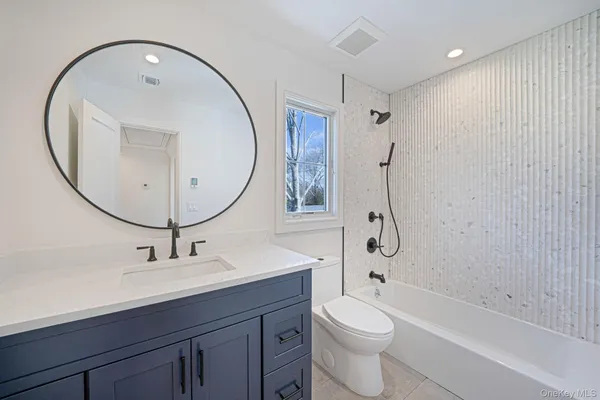 a bathroom with a sink a toilet and a mirror