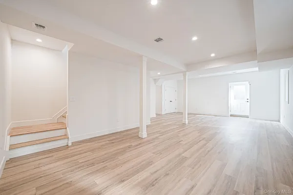 a view of empty room with wooden floor and entryway