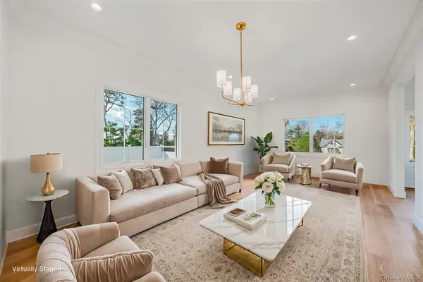 a living room with furniture or chandelier and a wooden floor