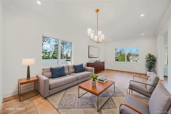 a living room with furniture a chandelier and a window