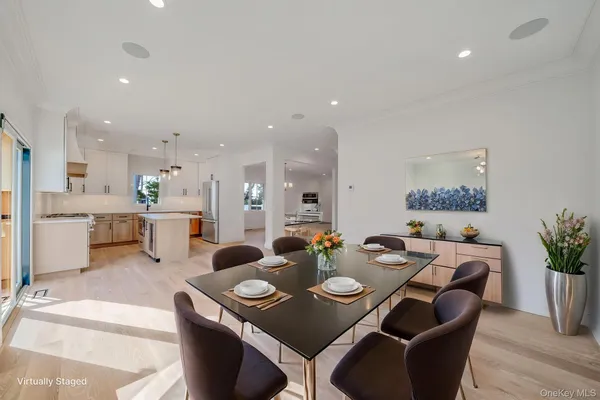 a dining room with furniture a potted plant and kitchen view