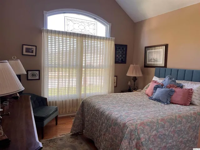 a bedroom with a bed windows and a desk