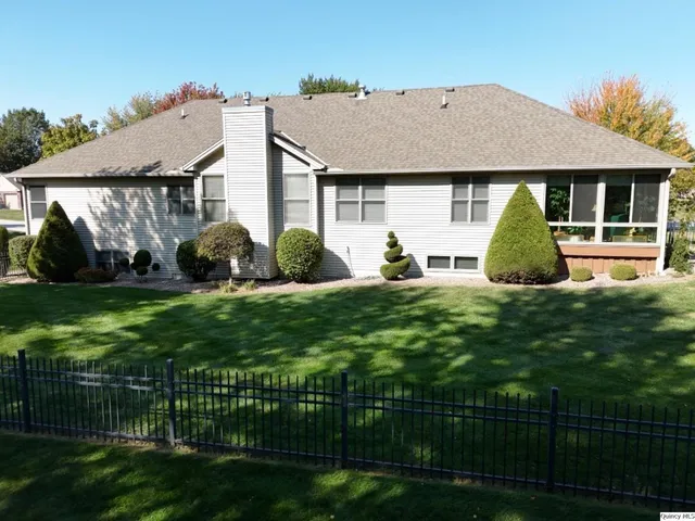 a front view of a house with a garden and plants