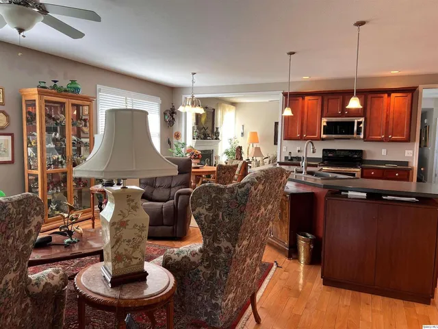a living room with furniture a large window and a wooden floor