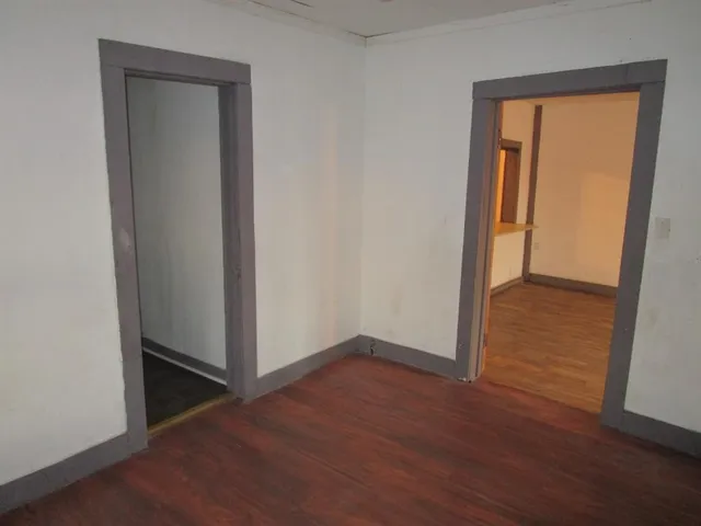 an empty room with wooden floor and closet