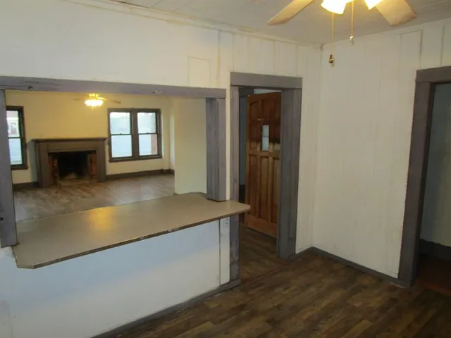 an entryway with a hallway and a livingroom with fireplace