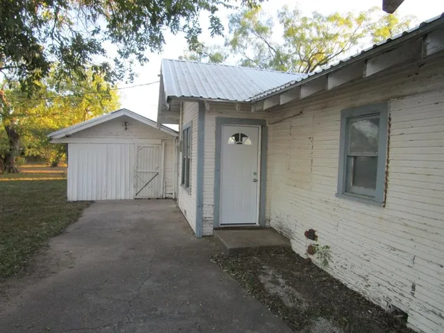 a view of a house with a yard and large tree