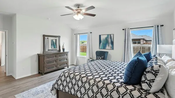 a bedroom with a bed and dresser with mirror