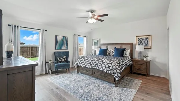 a bedroom with a bed and dresser with chair