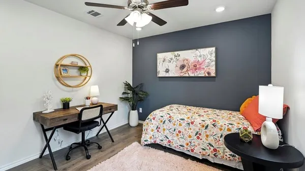 a bedroom with a large bed a chandelier and dresser