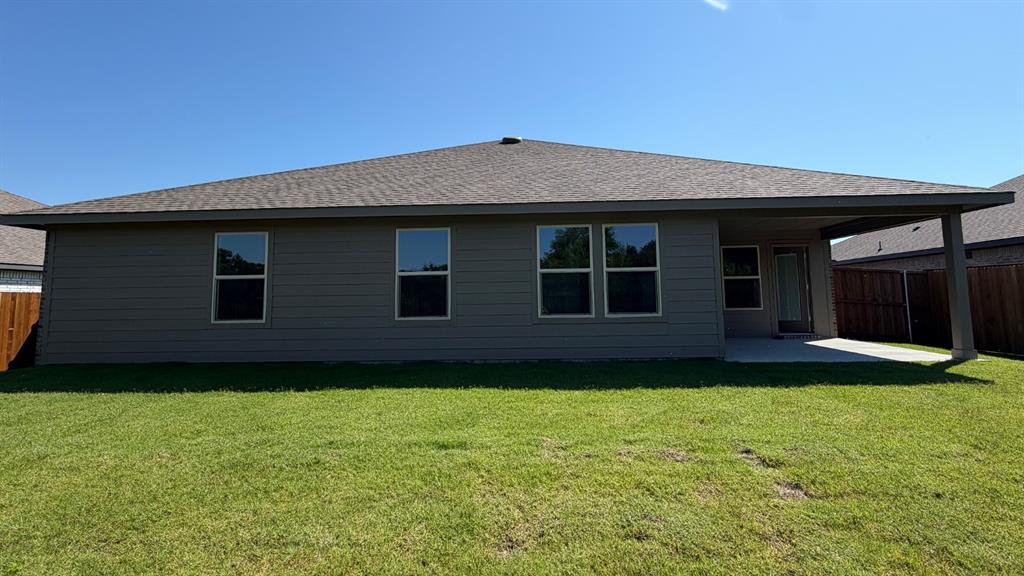 1911 Reveille Way Terrell, TX 75160 - Photo 36 of 39 Expansive backyard featuring a manicured lawn, a large covered patio, and privacy fencing