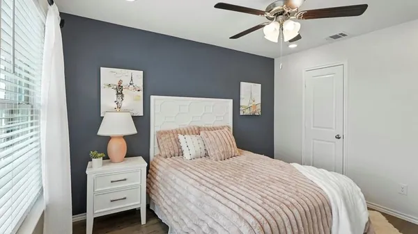 a bedroom with a bed a chandelier and a dresser