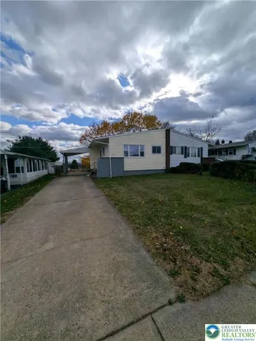 a view of a house with a yard and sitting area