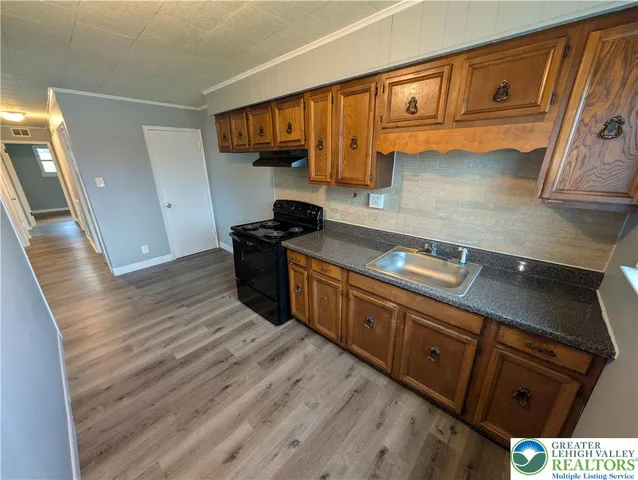 a kitchen with wooden cabinets and a stove top oven