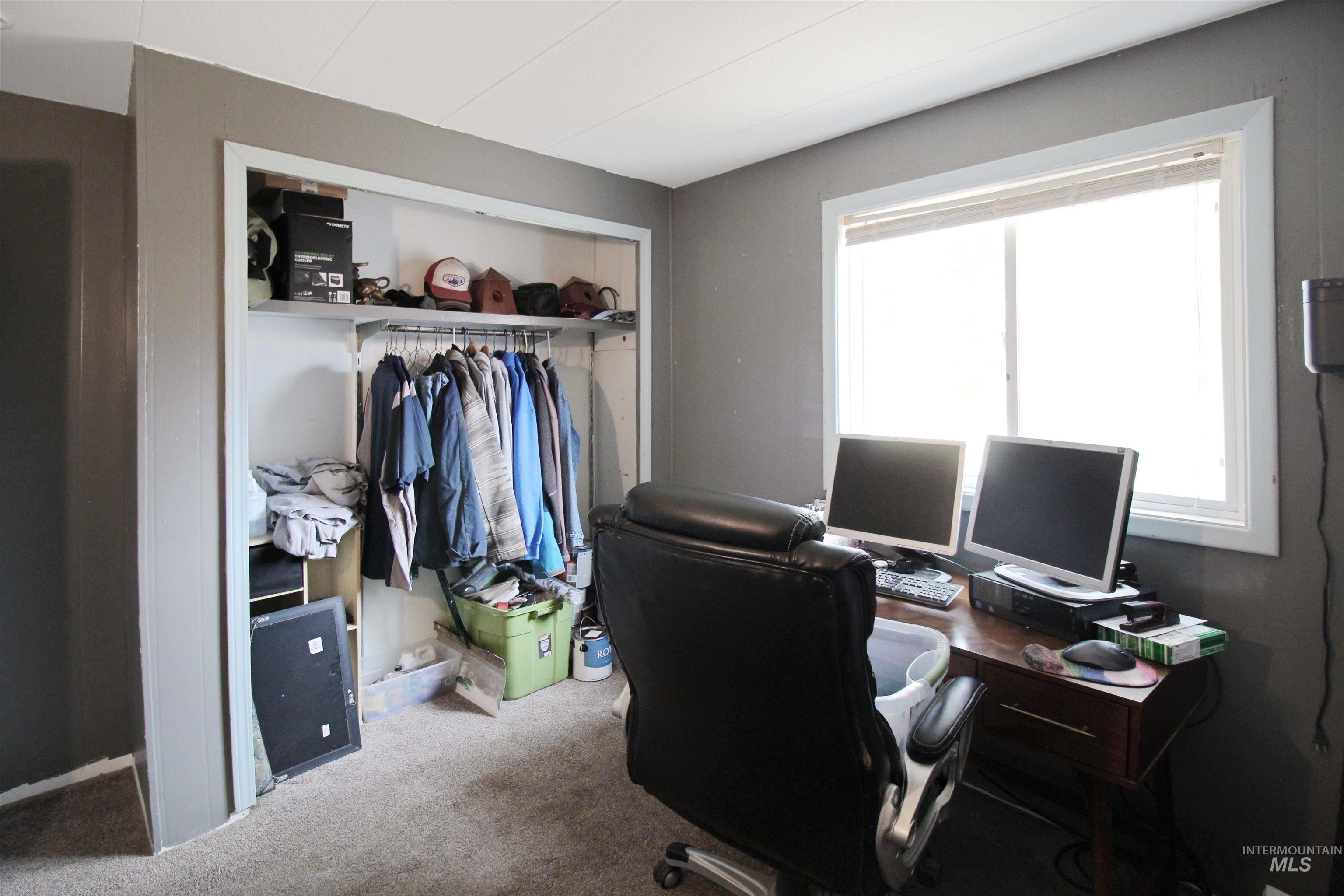 1265 Pioneer Road Weiser, ID 83672 - Photo 14 of 29 Room featuring a large window, a closet with shelving and a hanging rod, and carpet flooring
