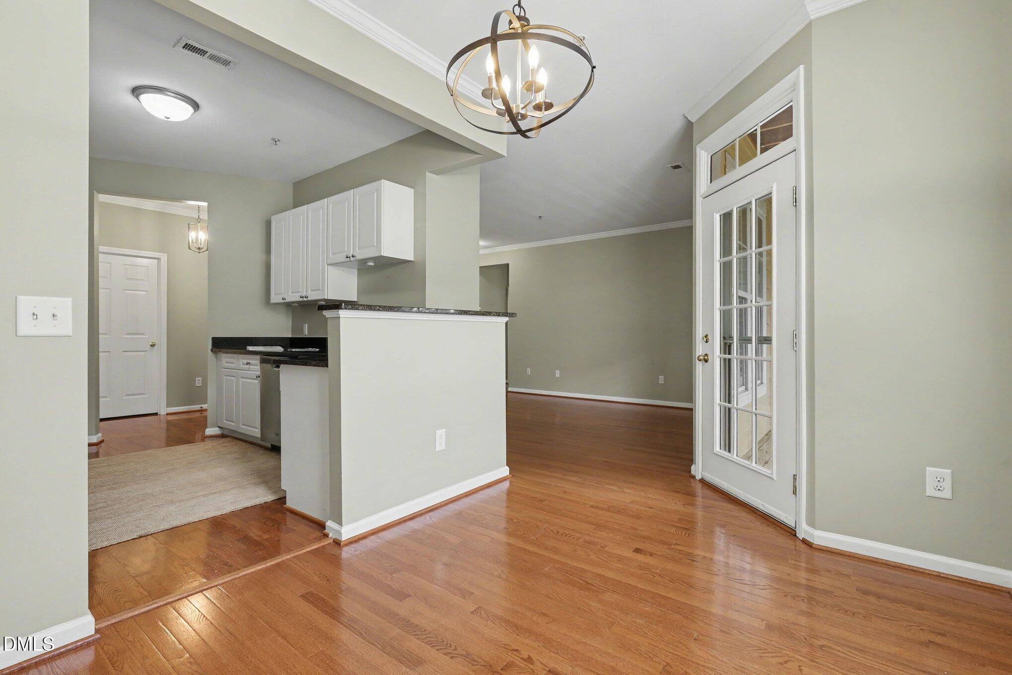 3121 Hemlock Forest Circle, Unit 203 Raleigh, NC 27612 - Photo 12 of 33 a view of kitchen and empty room with wooden floor