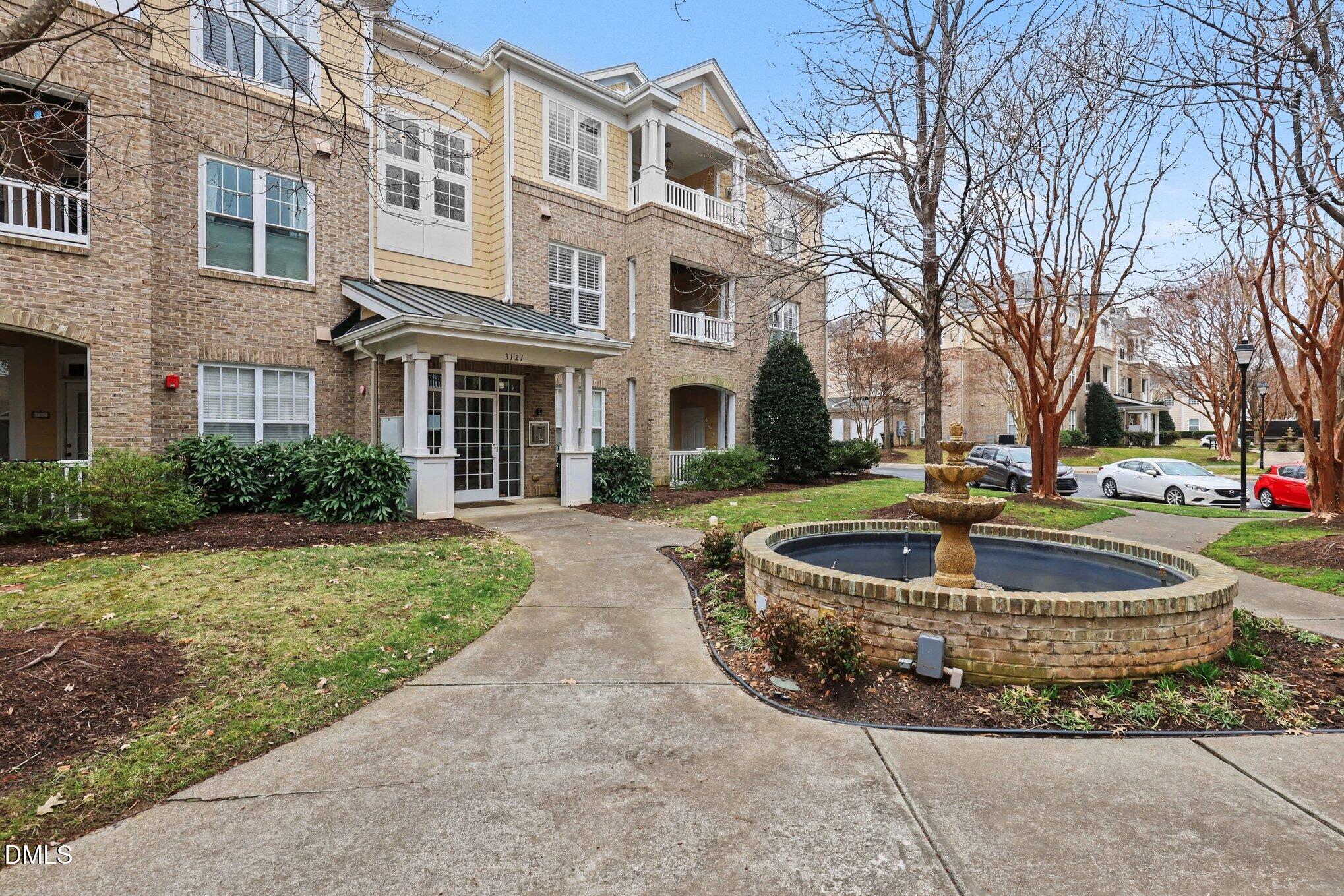 3121 Hemlock Forest Circle, Unit 203 Raleigh, NC 27612 - Photo 2 of 33 a front view of a building with fountain and trees