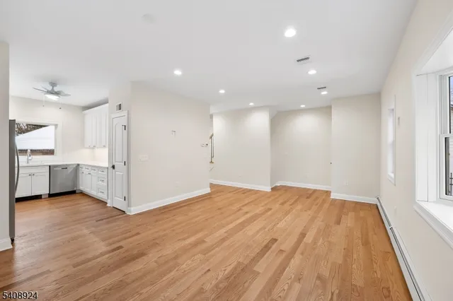 a view of a kitchen with wooden floor and windows