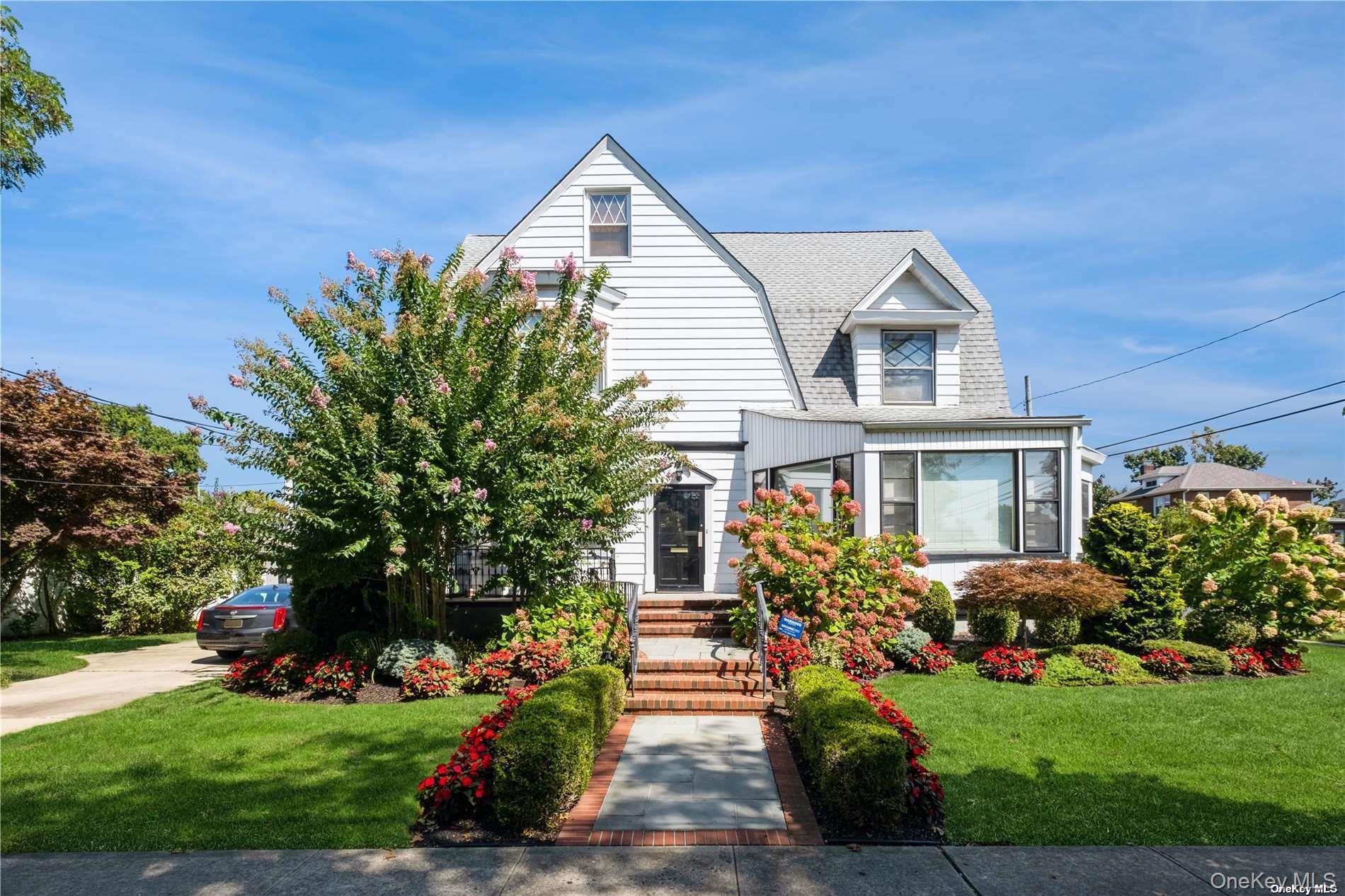 a front view of a house with a yard and potted plants