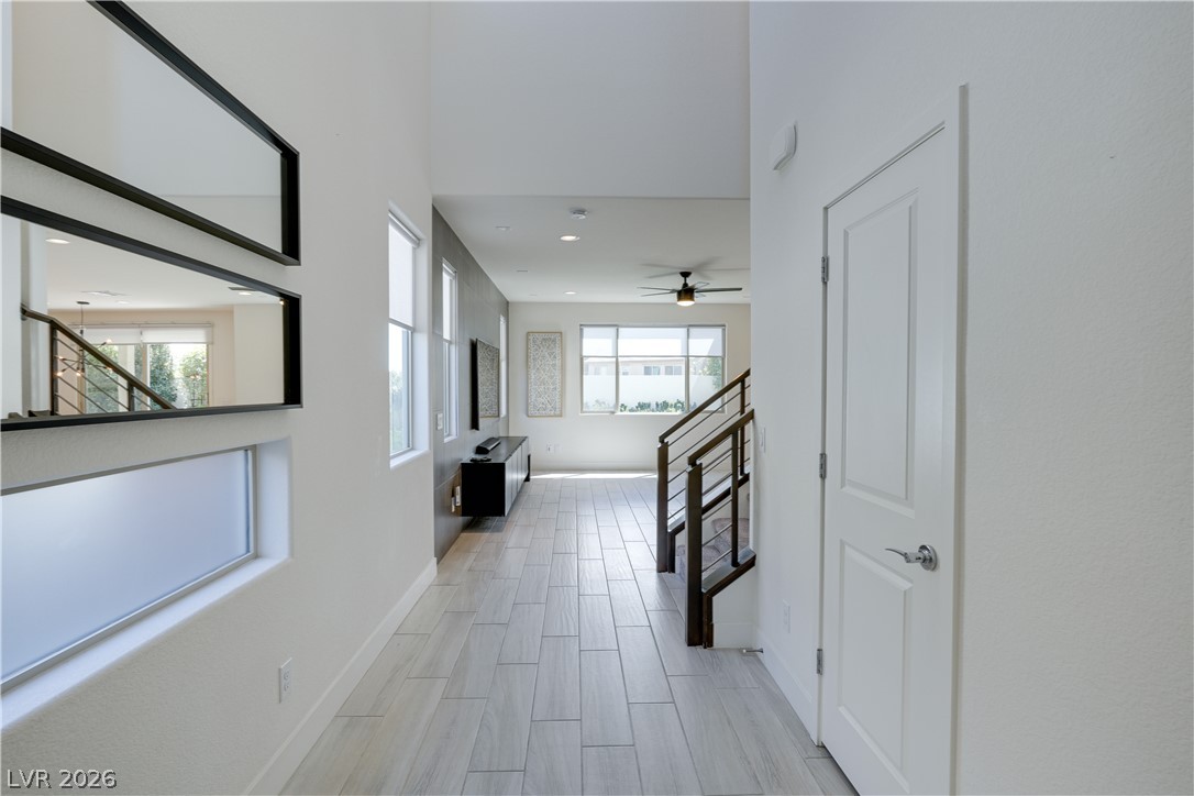 5954 Smith Valley Road Las Vegas, NV 89148 - Photo 9 of 23 A well-lit hallway presents a sleek aesthetic, showcasing durable tile flooring and modern architectural lines.