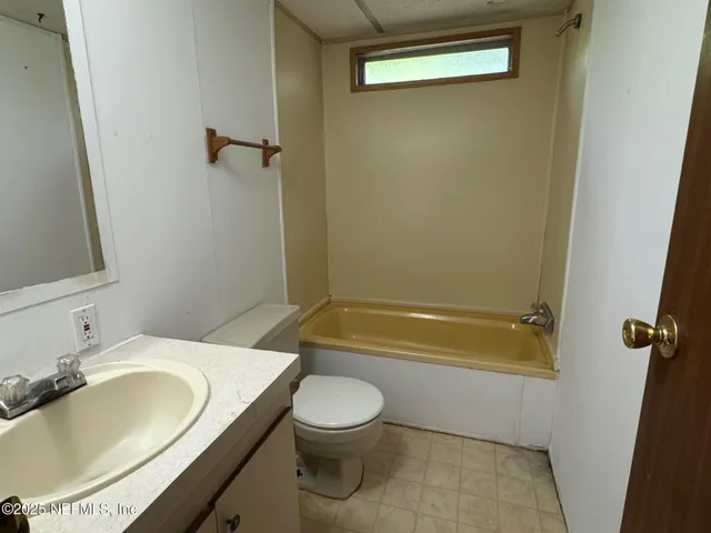 a bathroom with a granite countertop sink a toilet and bathtub