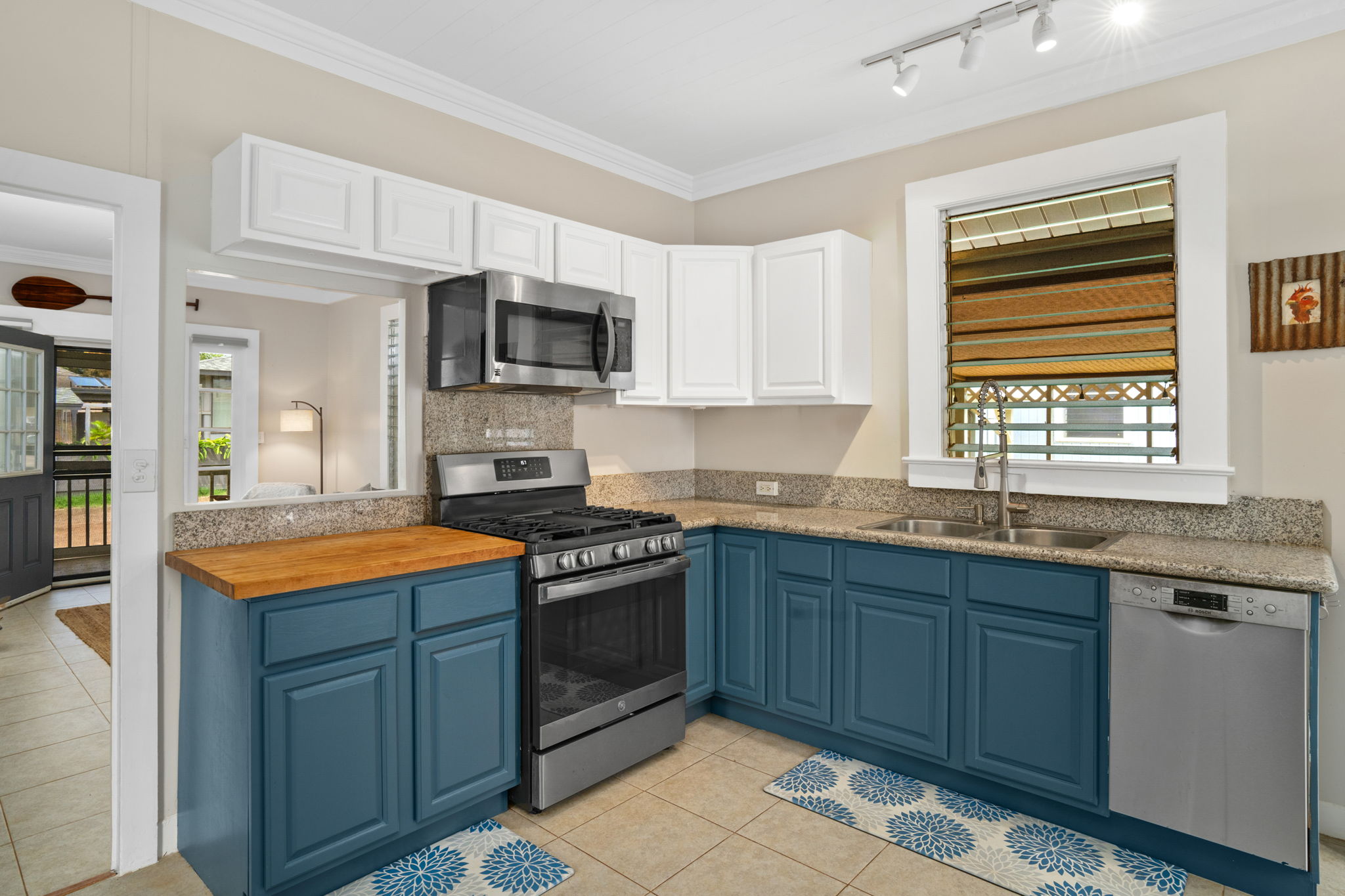 4780 Iiwi Road, Unit 1 Kapaa, HI 96746 - Photo 1 of 24 a kitchen with stainless steel appliances granite countertop a stove sink microwave and cabinets
