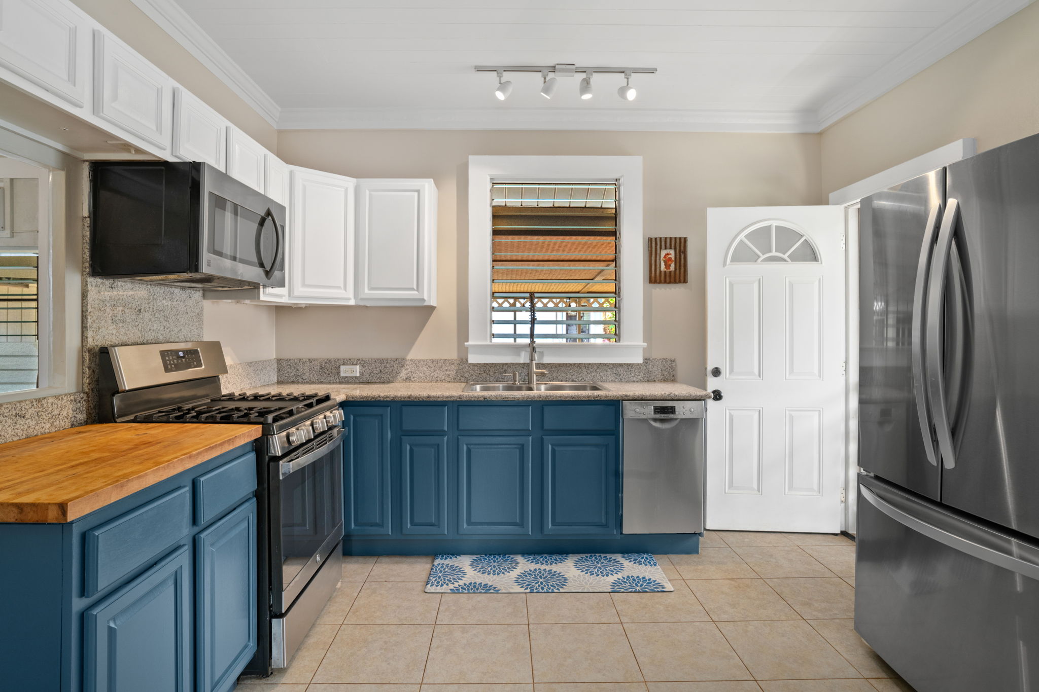 4780 Iiwi Road, Unit 1 Kapaa, HI 96746 - Photo 4 of 24 a kitchen with stainless steel appliances granite countertop a refrigerator stove and sink